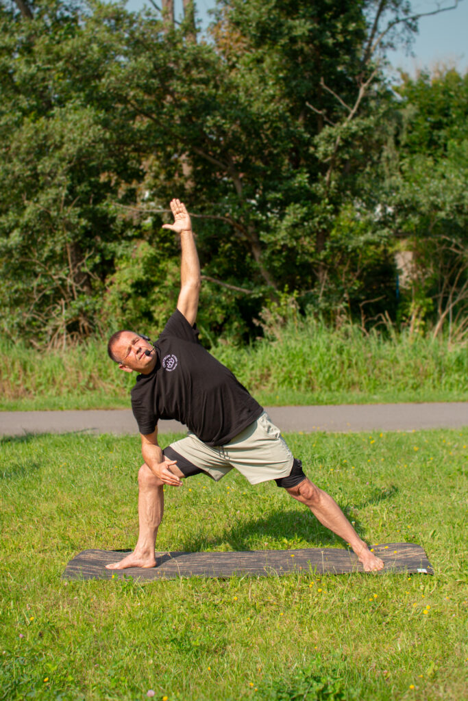 Praktyka jogi na świeżym powietrzu w Iławie – uczestnik w pozycji jogi podczas zajęć organizowanych przez Ciało Umysł Emocje.
